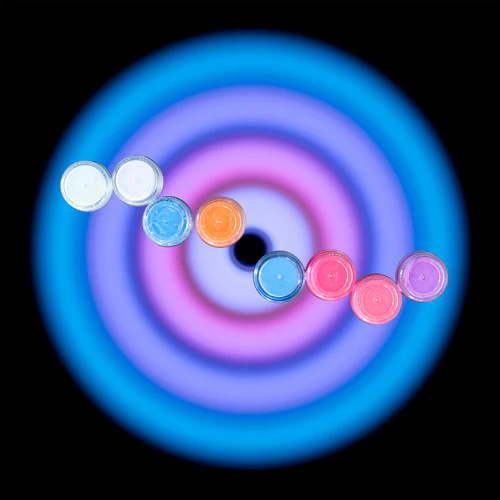 Eight containers arranged diagonally over a blue, violet, and pink Circular Light exposure